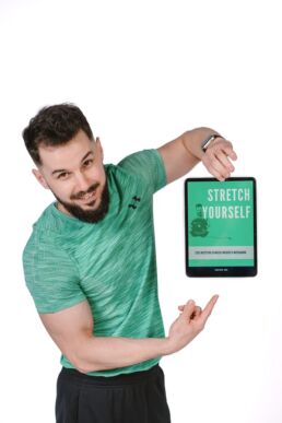 fotografia biznesowa Białystok portret mężczyzny w zielonym tshircie prezentującego swój ebook o rozciąganiu